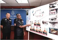  ?? — Bernama photo ?? Kumar points to photos showing the damage caused by the syndicate members on their victims’ properties.