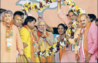  ?? MANOJ DHAKA/HT ?? Prime Minister Narendra Modi being welcomed by BJP leaders at a rally he addressed in favour of party candidate from Dadri assembly segment Babita Phogat on Tuesday.