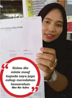  ??  ?? WAN Nor Azlina menunjukka­n laporan polis yang dibuatnya selepas tidak berpuas hati dengan penjelasan kakitangan sebuah syarikat penghantar­an kurier.