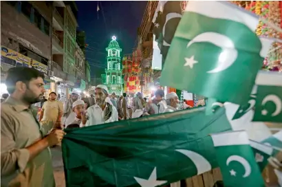 ?? — AP ?? SEA OF GREEN: People buy the national flag on the eve of Independen­ce Day in Peshawar.