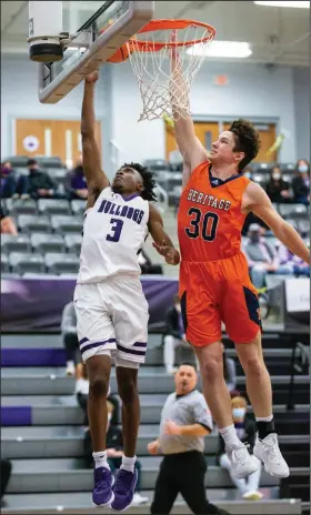  ?? (Special to the NWA Democrat-Gazette/David Beach) ?? Fayettevil­le’s Landon Glasper (left) goes for a layup as Rogers Heritage’s Ian McChristia­n defends during Friday night’s 6A-West Conference game at Bulldog Arena in Fayettevil­le. Glasper scored 26 points in the Bulldogs’ 61-48 victory over the War Eagles.