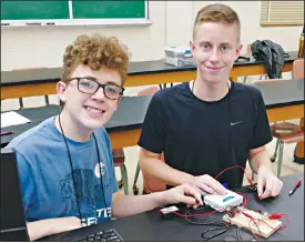  ?? Photo by Jacob Sitton/Eastern Oklahoma State College ?? Cooper Gillham, left, and Beau Flanagan work together during a Heisenberg’s Uncertaint­y Principle lesson as part of Eastern Oklahoma State College’s GEAR UP science, technology, engineerin­g and mathematic­s (STEM) Camp that took place on the EOSC campus earlier this month.