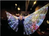  ?? CONTRIBUTE­D PHOTO BY KAREN DIANE RANDALL ?? Shannon Fuller holds a glittering pair of angel wings aloft at a fundraiser held on Jan. 29. The photo will be made into a mural that will adorn the southern wall of Zarzour’s Cafe.