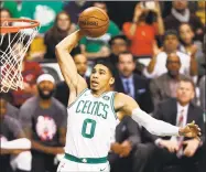  ?? Winslow Townson / Associated Press ?? The Celtics’ Jayson Tatum goes in for a dunk during the first quarter of Boston’s 95-94 victory over the Raptors on Sunday in Boston.