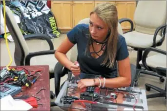  ?? PHOTO BY SHARON SHERIDAN ?? Lauren Piatti works on an electrical board for a robot that will compete in the Mount Olive District Competitio­n from March 9-11.