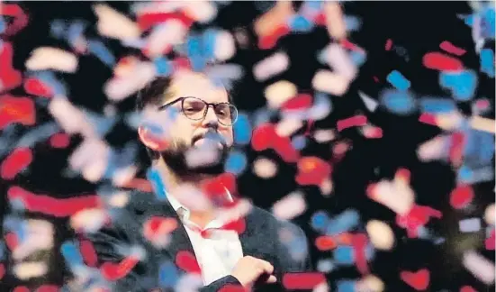  ?? JAVIER TORRES / AFP ?? Gabriel Boric, entre confeti amb els colors de la bandera xilena, celebrant el seu triomf diumenge a l’Alameda de Santiago