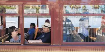  ?? Katie Falkenberg
Los Angeles Times ?? PASSENGERS take in the scenery from the Red Car. The venerable rail line will be taken out of service on Sunday; it was brought back a decade ago in hopes it would spark a revitaliza­tion of San Pedro’s waterfront.