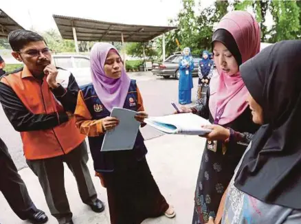  ?? [FOTO ROSLIN MAT TAHIR/BH] ?? Pegawai JPM Selangor melakukan bancian HIES terhadap seorang suri rumah sambil diperhatik­an Mohd Uzir (kiri) di Taman Seri Pekan, Klang, semalam.