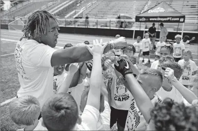  ?? [KYLE ROBERTSON/DISPATCH] ?? Snell breaks from a huddle with campers. Snell presented the Snell Yeah camp with the help of the Justice Action Network.