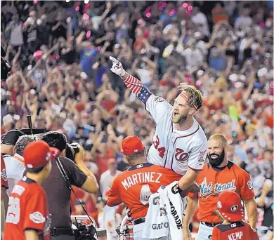  ?? KATHERINE FREY/WASHINGTON POST ?? Washington’s Bryce Harper celebrates with his manager, Davey Martinez, after winning the Home Run Derby Monday in front of his home fans at Nationals Park.