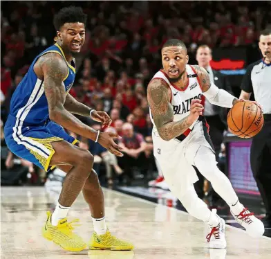  ?? — AFP ?? Opportune moment: Portland Trail Blazers’ Damian Lillard (right) going for the basket during the NBA Western Conference final against Golden State Warriors at the Moda Centre in Portland on Monday.