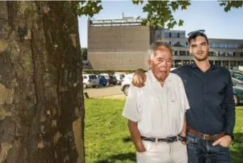  ?? © Fred Debrock ?? Elio De Bolle met zijn grootvader. Op de achtergron­d de betwiste slogan ‘Dilbeek, waar Vlamingen thuis zijn’, op het cultuurcen­trum De Westrand.