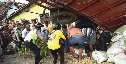  ?? TERGUH SUPRIYANTO/RADAR TEGAL ?? EVAKUASI: Warga dan polisi mengeluark­an korban yang tertimpa truk di jalan nasional Tegal-Purwokerto wilayah Paguyangan, Brebes, kemarin.