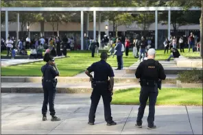  ?? (AP/Houston Chronicle/Karen Warren) ?? Houston police officers watch over displaced churchgoer­s outside Lakewood Church, after a reported shooting during a Spanish church service on Sunday.