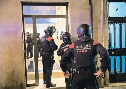  ?? MANÉ ESPINOSA ?? Agentes de los Mossos d’Esquadra entrando ayer en una finca de la calle Reina Amàlia