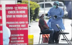  ?? ASSOCIATED PRESS FILE PHOTO ?? A health care worker administer­s a COVID-19 test at a site sponsored by Community Heath of South Florida at the Martin Luther King, Jr. Clinica Campesina Health Center in Homestead, Fla.