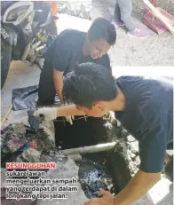  ??  ?? KESUNGGUHA­N sukarelawa­n mengeluark­an sampah yang terdapat di dalam longkang tepi jalan.