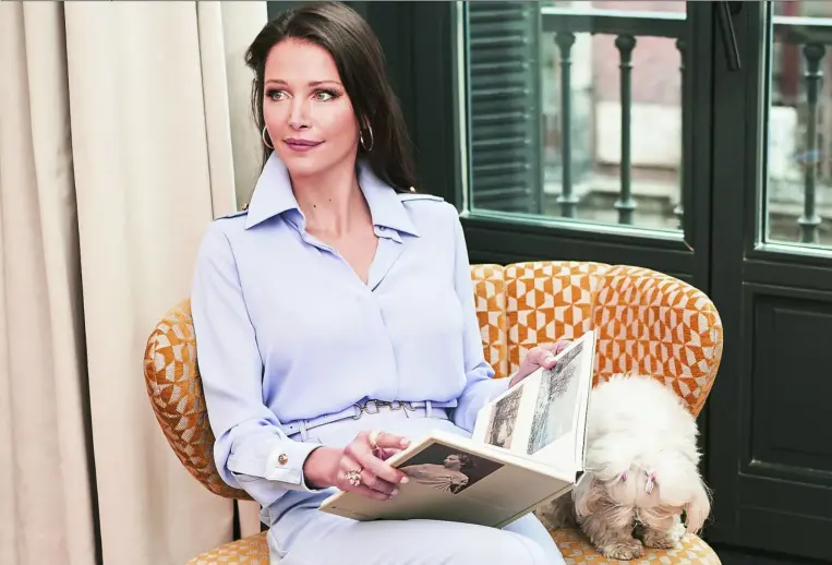  ??  ?? Esther Doña leyendo un libro de la colección de libros de arte del Museo Nacional Thyssen-bornemisza con camisa y pantalón en malva de Elisabetta Franchi