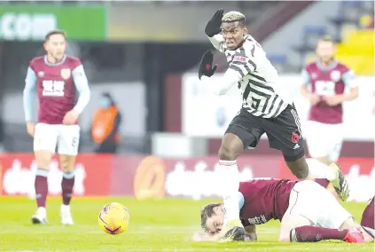  ??  ?? Manchester United's French midfielder Paul Pogba (C) runs over Burnley's English striker Ashley Barnes during the football match at Turf Moor in Burnley. - AFP photo