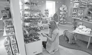  ?? BARBARA J. PERENIC/COLUMBUS DISPATCH ?? Owner Enas Lanham rearranges a display of toy vehicles in the Dublin Toy Emporium. Holiday shoppers have returned to stores this year, and online sales dipped on Black Friday.