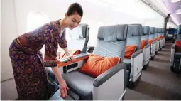  ??  ?? A flight attendant arranges a premium class seat of a Singapore Airlines Ltd. Airbus SE A380 aircraft with refitted cabins during a media tour at Changi Airport in Singapore, on Thursday, Dec. 14, 2017. (Bloomberg)