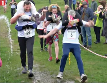  ??  ?? Going... Christophe­r Burke slips on a patch of mud while carrying his wife Kate n1