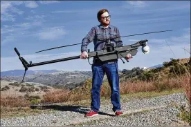  ?? PHILIP CHEUNG / THE NEW YORK TIMES ?? Brian Schimpf, chief executive of Anduril, holds a Ghost drone at a testing area near Camp Pendleton, Calif. Anduril’s drones can identify and track vehicles, people and other objects largely on their own.