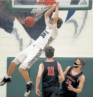 ?? Photos by Andy Cross, The Denver Post ?? ThunderRid­ge’s Zach Keller dunks over Castle View defenders during the first half at ThunderRid­ge High School on Feb.