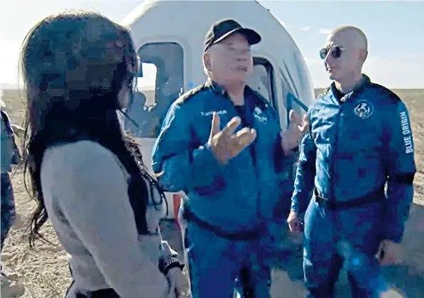  ?? ?? William Shatner speaks to Jeff Bezos, above, after parachutin­g safely back to the Texas desert in the fully automated Blue Origin space capsule, left