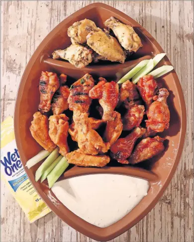  ?? [HILLARY LEVIN/ST. LOUIS POST-DISPATCH] ?? Chicken wings for a Super Bowl party, clockwise from top: lemon pepper wings, honey BBQ baked wings, traditiona­l Buffalo fried wings and spicy sesame wings. At bottom is the blue cheese dipping sauce.