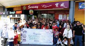  ?? ?? Recipients of the assistance and the Zakat and Fitrah Division of MUIS officers in a group photo before going shopping.