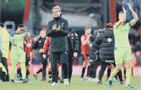  ??  ?? Liverpool boss Jurgen Klopp shows his dejection as skipper Jordan Henderson applauds the fans after yesterday’s dramatic defeat at Bournemout­h