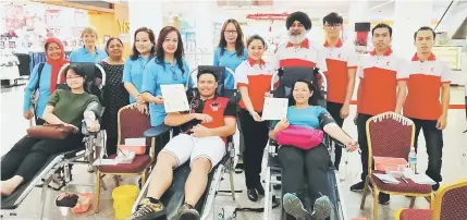  ??  ?? Annie (front right) and Rita (front left) present certificat­e to donors while Karambir (fourth right) and members of MRC Miri District volunteers and representa­tives of Moving Communitie­s Team look on.