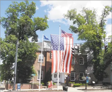  ?? Macklin Reid / Hearst Connecticu­t Media file photo ?? A giant American flag drapes the front of Ridgefield Town Hall on June 25, 2018. The flag has not been hung since two elm trees that supported it were removed later that month.