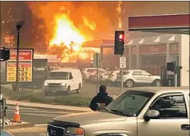  ?? David Demaree ?? THE INFERNO approaches the intersecti­on. Authoritie­s shepherded evacuees to a strip mall parking lot, then a coffee shop, until firefighte­rs ensured safe exit.