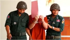  ??  ?? Jones (centre) is escorted by Cambodian prison guard at a court in Siem Reap. — AFP photo