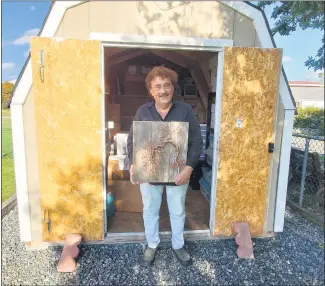  ?? ANDREW KULP - READING EAGLE ?? Boyertown resident Ron Stauffer stands outside the shed his Amazon prize winnings purchased for his copper art business, holding one of the copper wire bonsai trees he says are his favorite product.