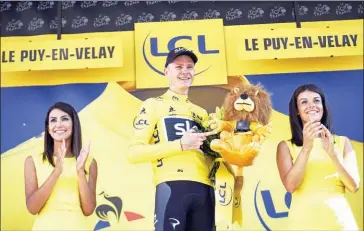  ?? LIONEL BONAVENTUR­E/AFP ?? Chris Froome stands on the podium in the overall leader’s yellow jersey at the end of the 189.5km 15th stage of the 104th edition of the Tour de France on Sunday.