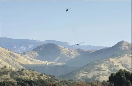  ?? Kings River Conservati­on Distric ?? A HELICOPTER tows an electromag­netic system near Pine Flat Dam during a survey of the Kings River alluvial fan in December 2020. Data from the system, which was developed in Denmark, provide a cross-section of the subsurface down to about 1,000 feet.