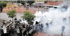  ??  ?? AP Police stand amid tear gas as they clash with supporters of opposition presidenti­al candidate Salvador Nasralla in Tegucigalp­a, Honduras, on Dec. 18, 2017.