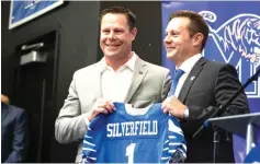  ?? Ariel Cobbert/
The Commercial Appeal via AP, File ?? ■ Memphis director of athletics Laird Veatch, left, presents Memphis head football coach Ryan Silverfiel­d, right, with a team jersey on Dec. 13, 2019, in Memphis, Tenn. As football players start returning to campus, college officials have a wide range of opinions on whether to let the public know how many of their athletes test positive for coronaviru­s.