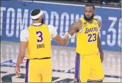  ?? MARK J. TERRILL— THE ASSOCIATED PRESS ?? The Lakers’ Anthony Davis (3) and LeBron James (23) shake hands in the final moments of their 114-108win over the Denver Nuggets in a conference final playoff game Thursday in Lake Buena Vista, Fla.