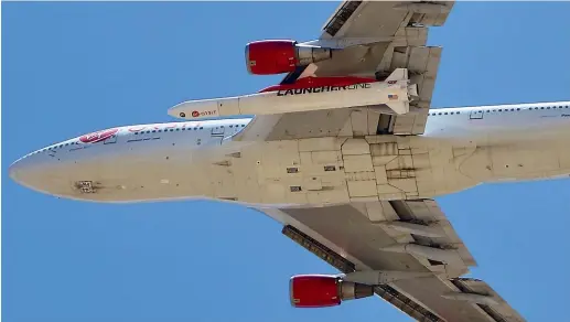  ?? AP ?? A Virgin Orbit Boeing 747-400 aircraft named Cosmic Girl takes off from Mojave Air and Space Port in the desert north of Los Angeles carrying Virgin Orbit’s LauncherOn­e rocket slung under the fuselage.