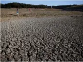  ?? Tribune News Service/getty Images ?? A family walks across dry cracked earth that used to be the bottom of Lake Mendocino on April 22, 2021, in Ukiah.