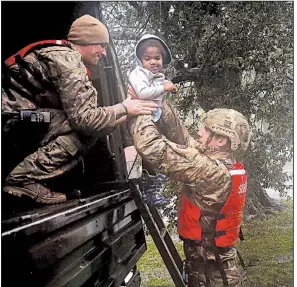  ?? AP/CHRIS SEWARD ?? Sgt. Matt Locke (left) and Sgt. Nick Muhar with the North Carolina National Guard help a child Friday as rising floodwater­s from Hurricane Florence threaten the family’s home in New Bern, N.C.