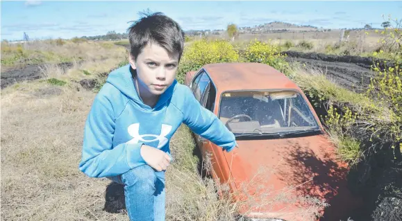  ?? Pictures: Tom Gillespie ?? ROAD RAGE: Huddson Smith points to a car that became trapped while driving along Oestreich Road in Wellcamp. Residents living along it say it needs an upgrade so emergency services and other organisati­ons can reach homes.