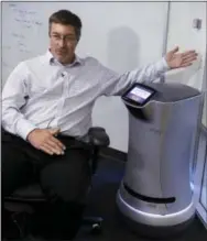  ?? THE ASSOCIATED PRESS ?? Steve Cousins, CEO of Savioke, talks while sitting next to a Relay robot at company headquarte­rs in San Jose, Calif. Tech companies insist their products will largely assist, and not displace, workers. Savioke makes the 3-foot-tall Relay robots that...