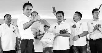  ??  ?? Parti Warisan Sabah representa­tive in Tungku, Assafal Alian handing over the 4,519 applicatio­n forms to Shafie.