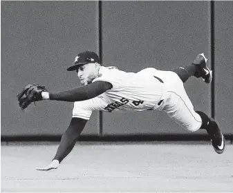  ?? Karen Warren / Staff photograph­er ?? Astros center fielder George Springer comes in a for a landing after snagging a sinking drive by the Athletics’ Khris Davis during the first inning Tuesday night.