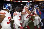  ?? ALEX BRANDON - THE ASSOCIATED PRESS ?? New York Giants outside linebacker David Mayo (55) lifts tight end Kaden Smith, center, after he caught the game-winning touchdown pass from quarterbac­k Daniel Jones during overtime of an NFL football game against the Washington Redskins, Sunday, Dec. 22, 2019, in Landover, Md. The Giants won 41-35 in overtime.